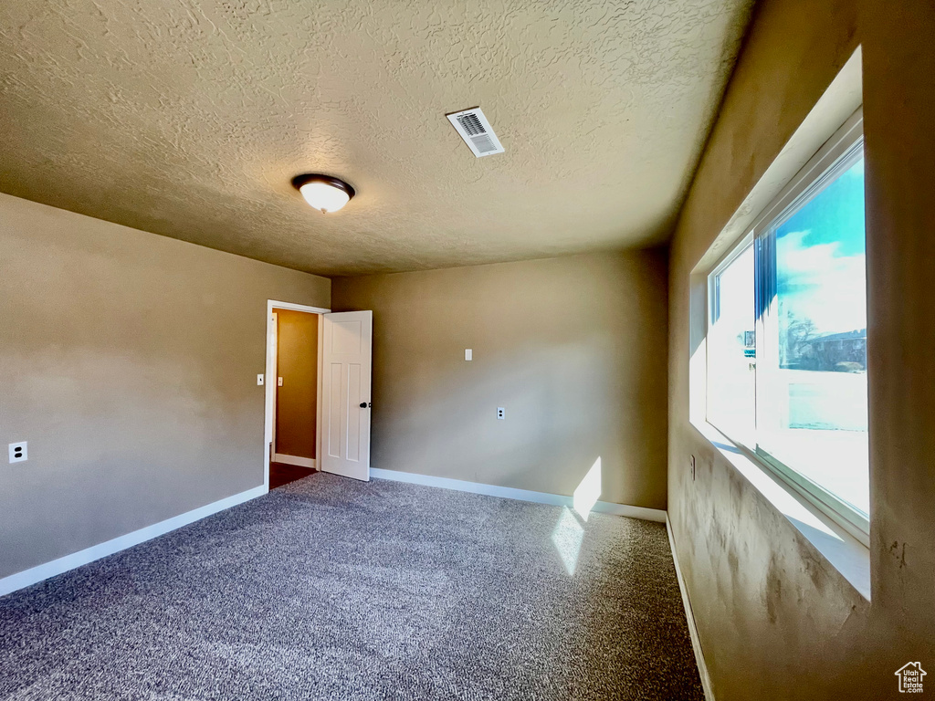 Unfurnished room with a textured ceiling