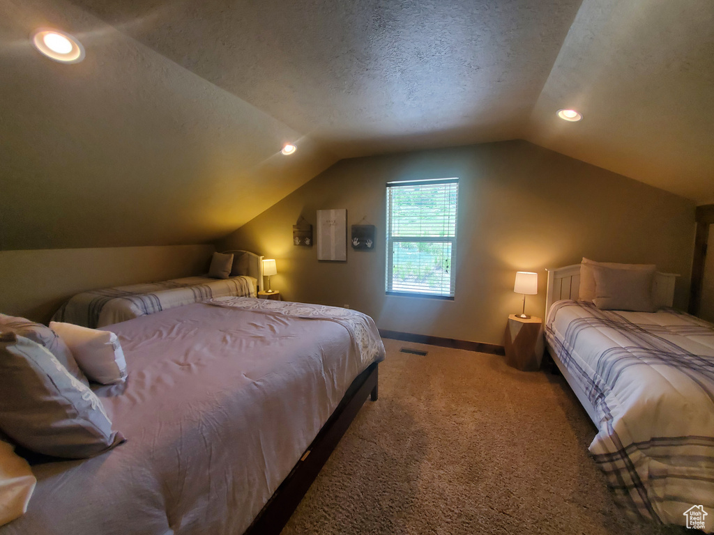 Carpeted bedroom with vaulted ceiling, baseboards, recessed lighting, and a textured ceiling