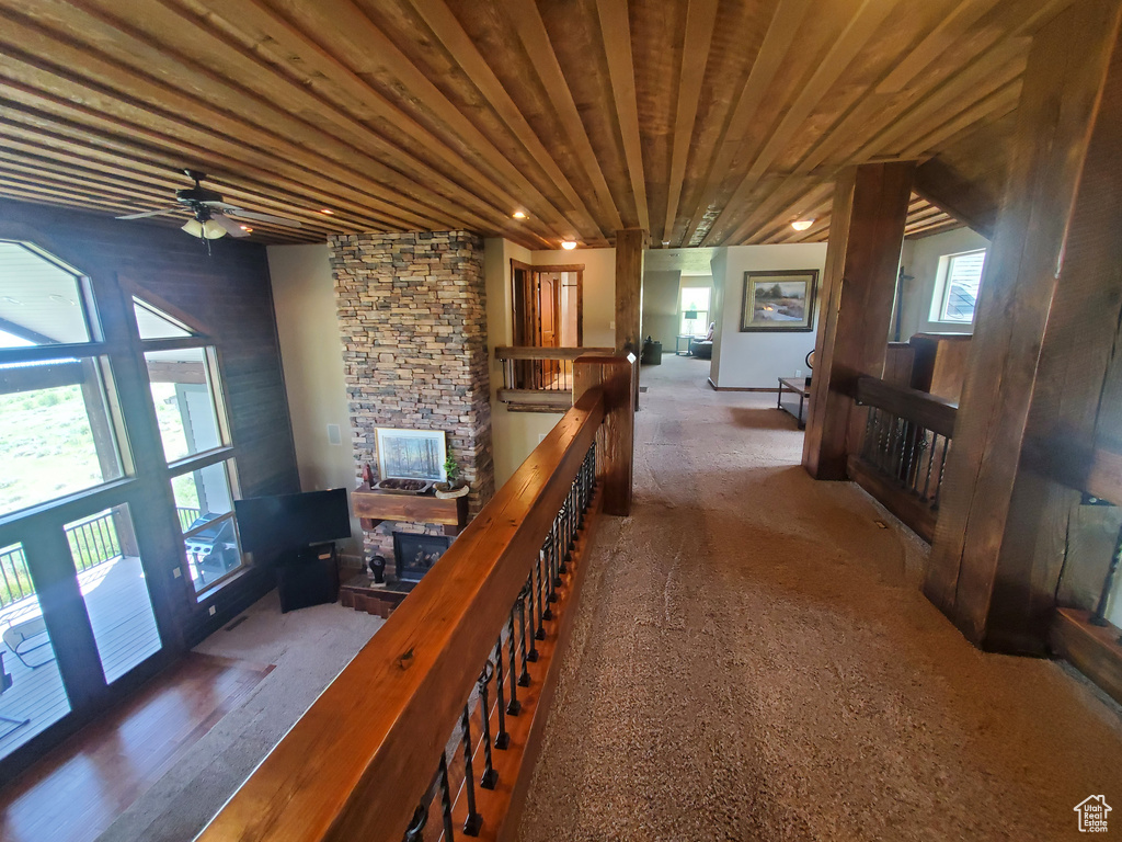 Hallway with an upstairs landing, carpet, and wood ceiling
