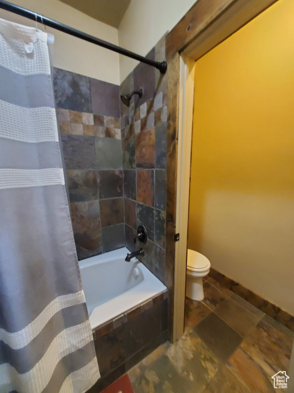 Full bathroom with toilet and tiled shower / bath combo