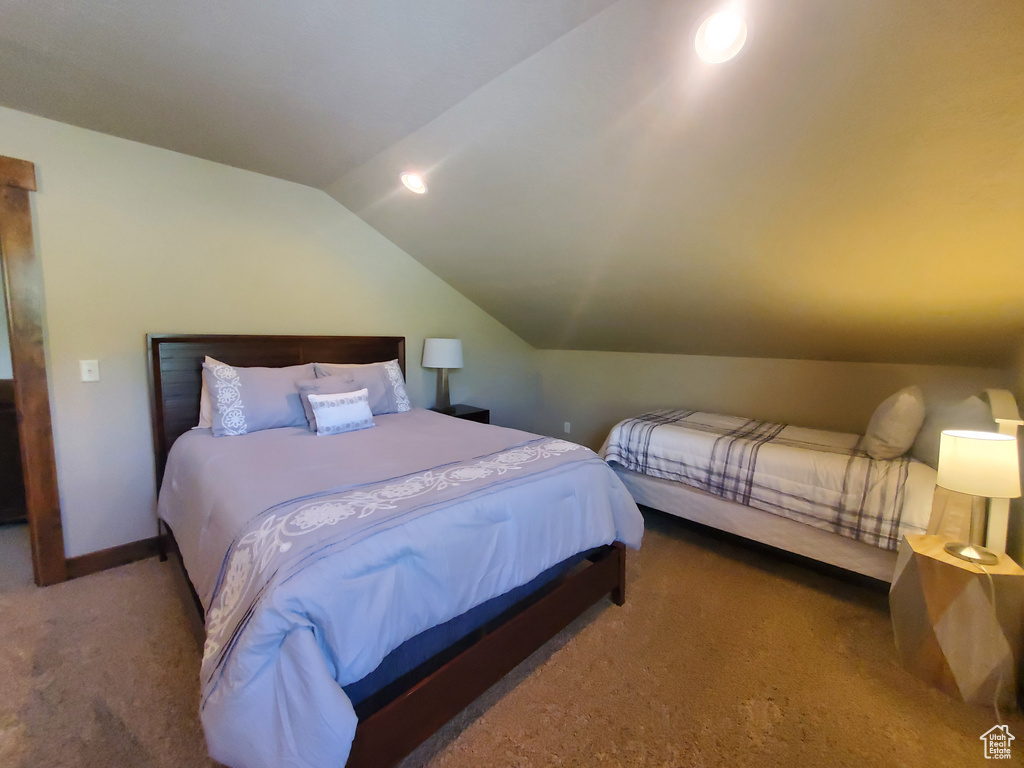 Bedroom with carpet, lofted ceiling, and baseboards
