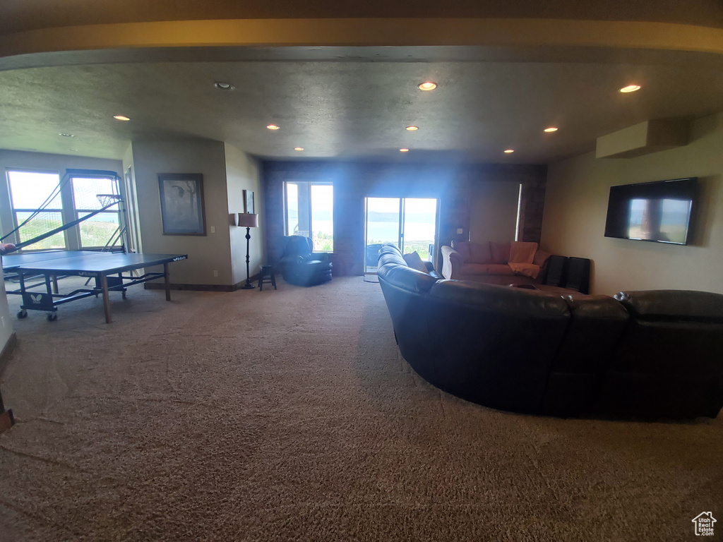 Carpeted living area featuring recessed lighting, healthy amount of natural light, and baseboards
