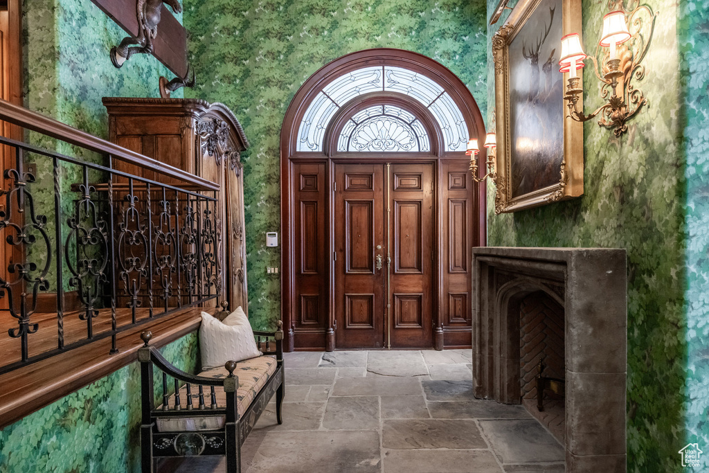 Entrance foyer with wallpapered walls and stone tile flooring