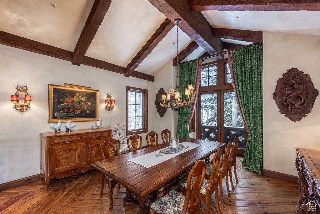 Dining room featuring parquet floors, an inviting chandelier, lofted ceiling with beams, and baseboards