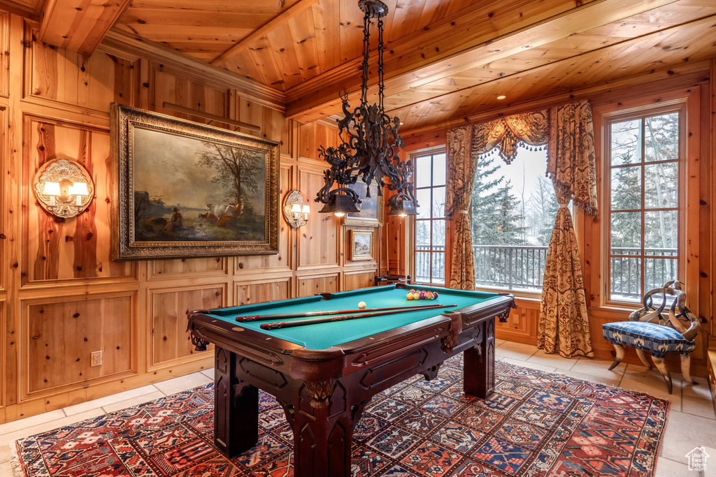 Recreation room with wood walls, wooden ceiling, light tile patterned floors, and pool table
