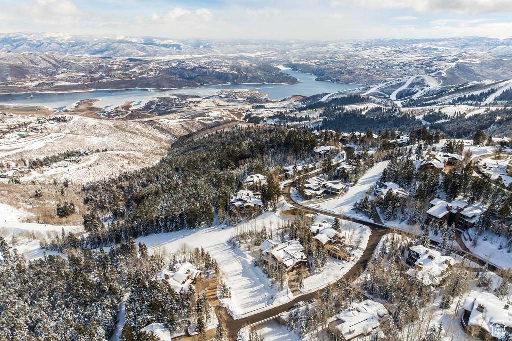 Snowy aerial view featuring a water and mountain view