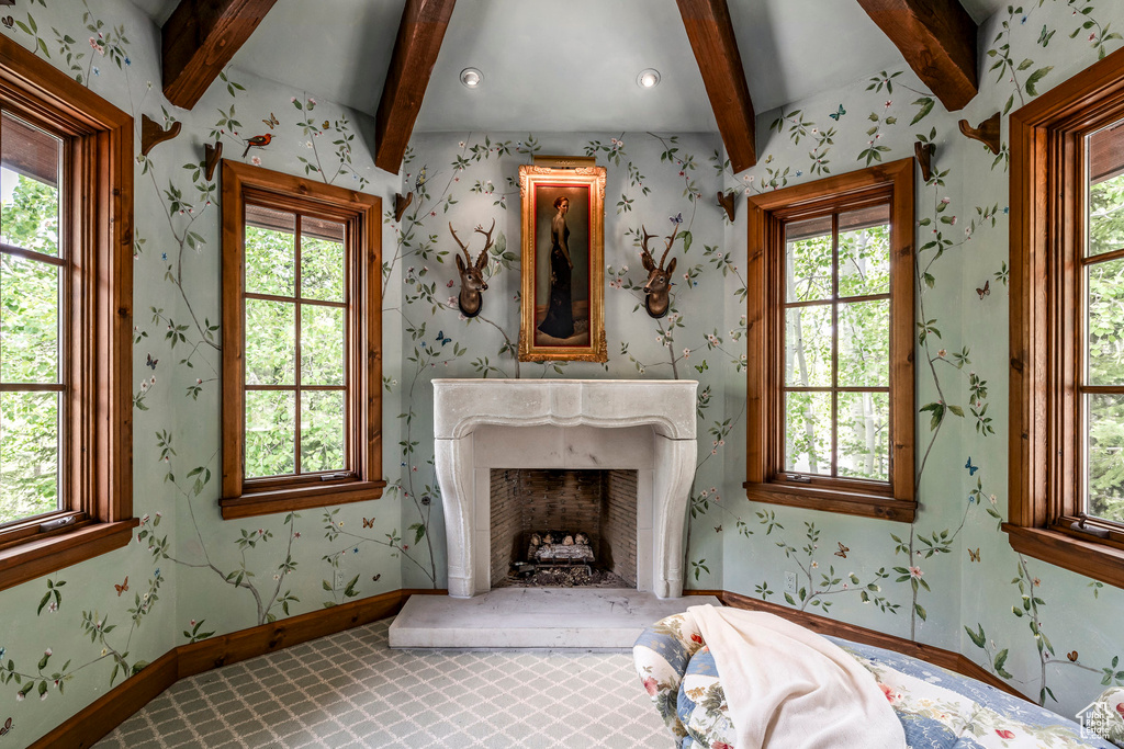 Bedroom featuring beamed ceiling, multiple windows, and a high end fireplace