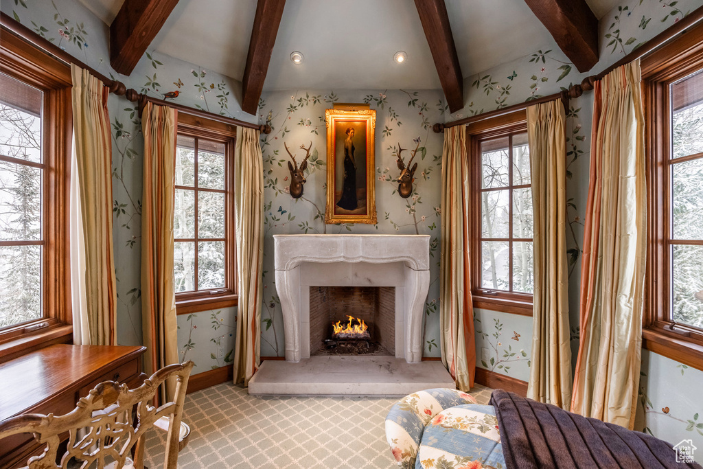 Unfurnished living room featuring wallpapered walls, baseboards, and a wealth of natural light