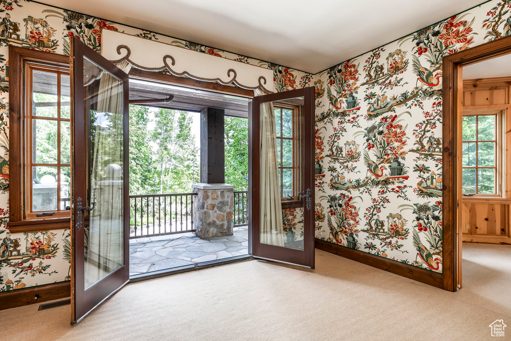 Doorway to outside featuring wallpapered walls, french doors, and carpet flooring