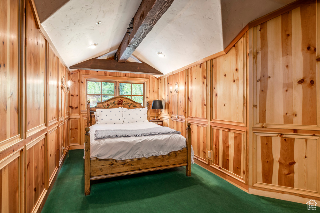 Bedroom with dark colored carpet and wood walls
