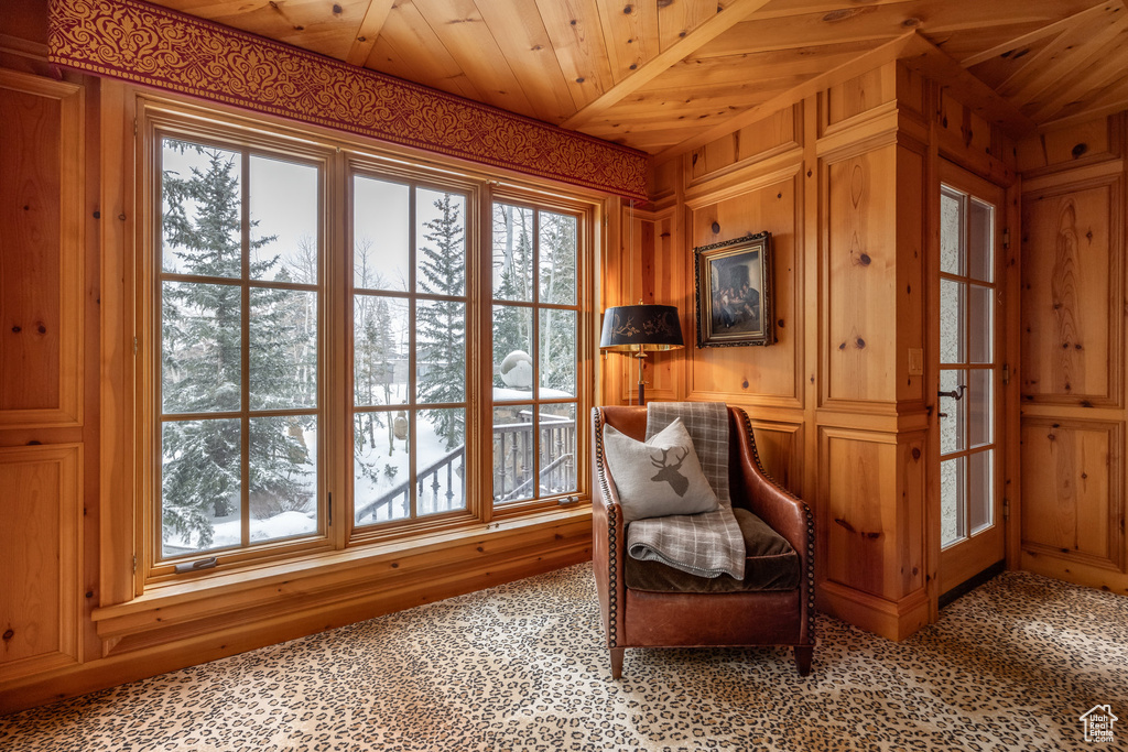 Sitting room featuring wood walls, light colored carpet, and wood ceiling