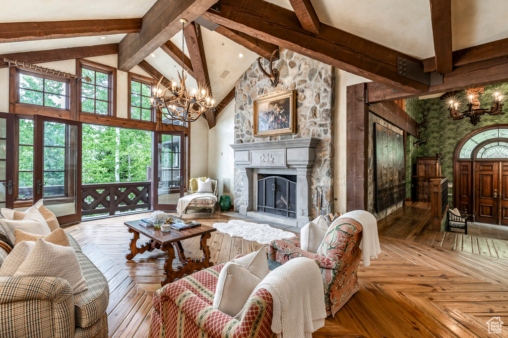 Living room featuring a chandelier, high vaulted ceiling, beam ceiling, and a fireplace