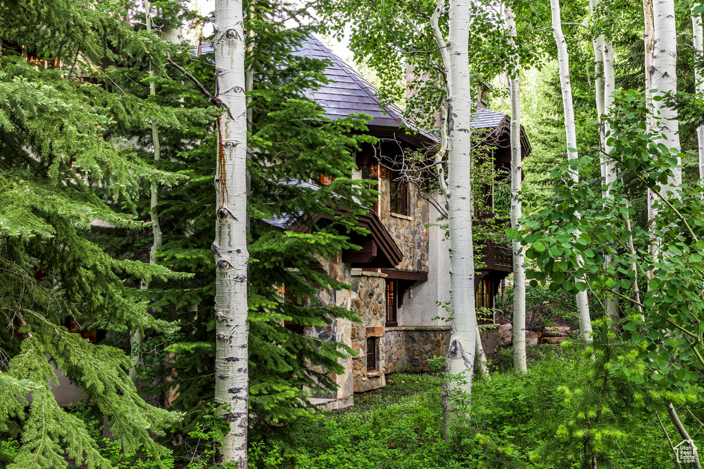 View of home\'s exterior featuring stone siding and roof with shingles