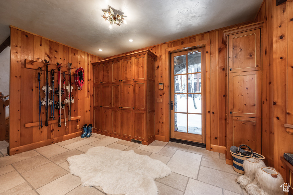 Entryway featuring wood walls, baseboards, recessed lighting, and stone tile flooring