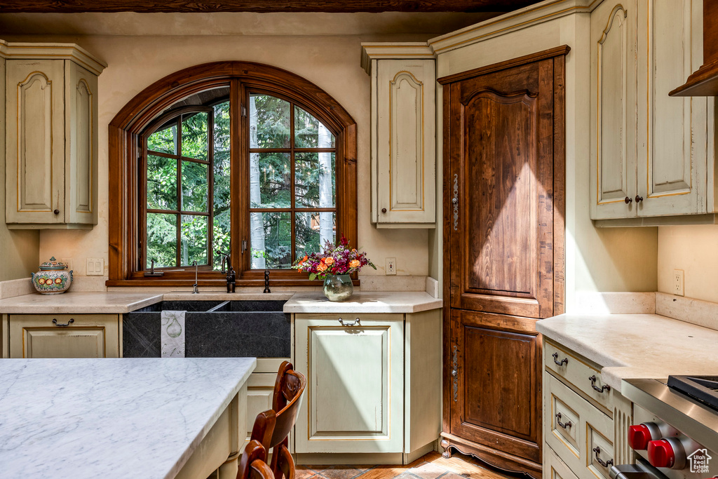 Kitchen featuring cream cabinetry, light countertops, and range