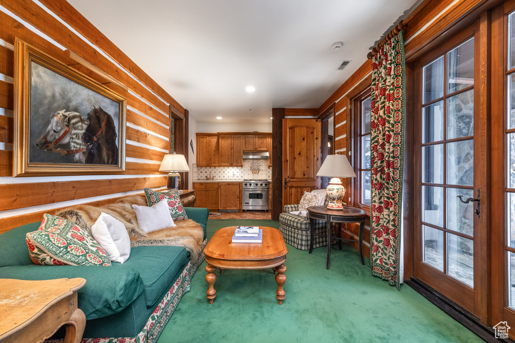 Living area with visible vents, carpet, and a healthy amount of sunlight