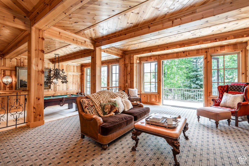 Living area featuring pool table, carpet, wood walls, and wooden ceiling