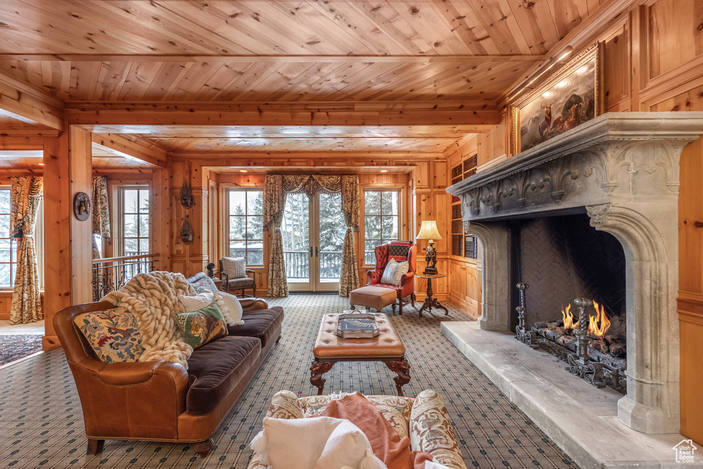 Living room featuring wood ceiling, french doors, wooden walls, and a fireplace