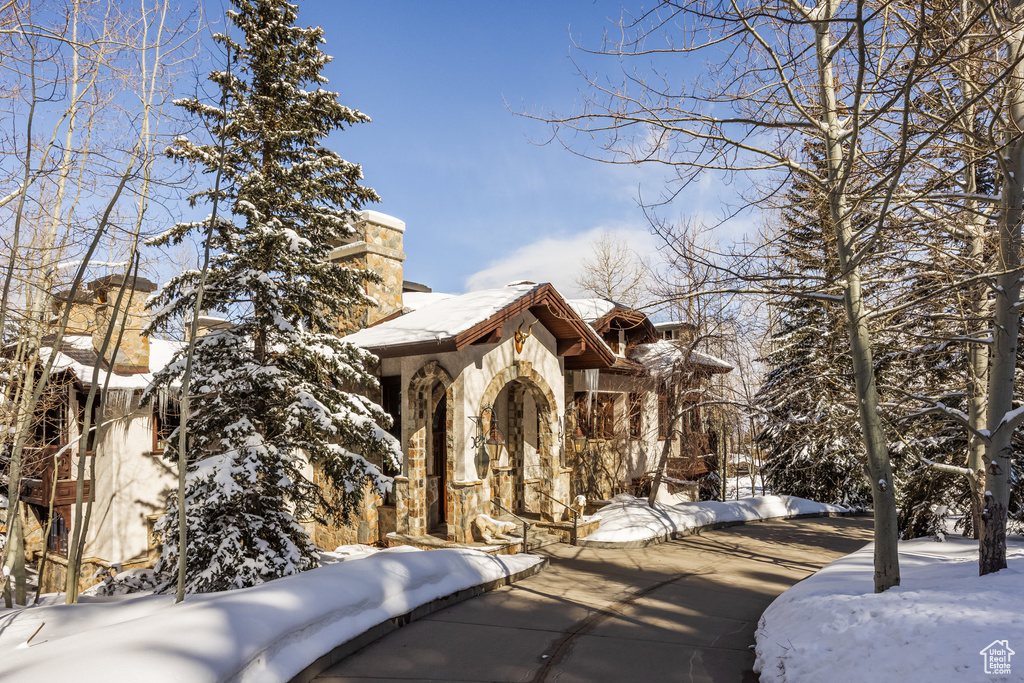 Exterior space featuring stone siding and a chimney