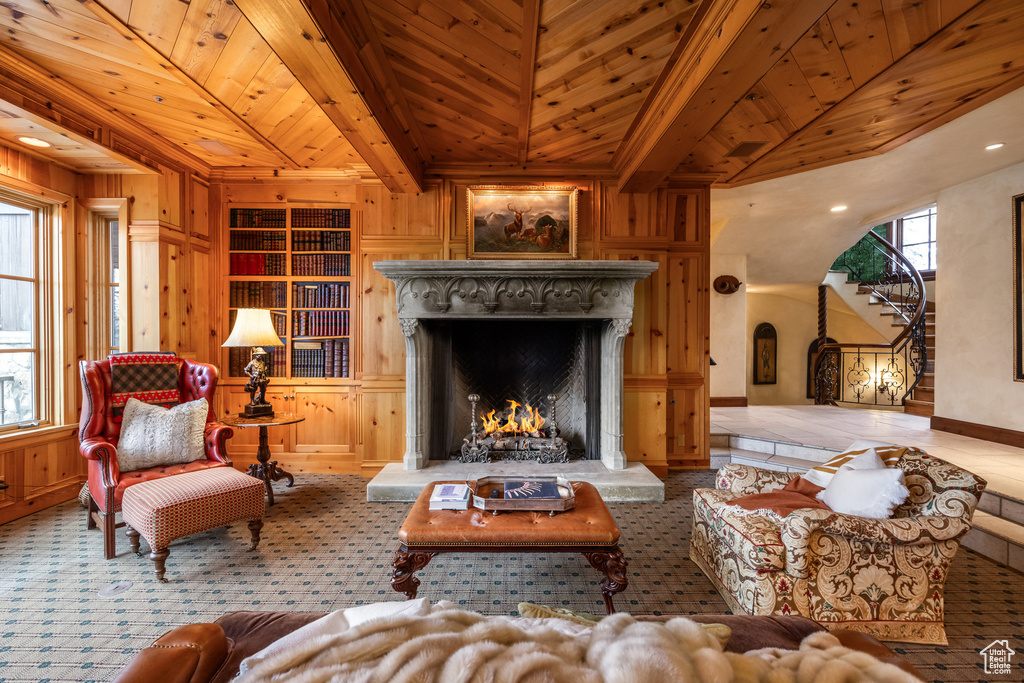 Living area featuring a premium fireplace, wood ceiling, built in features, and wood walls