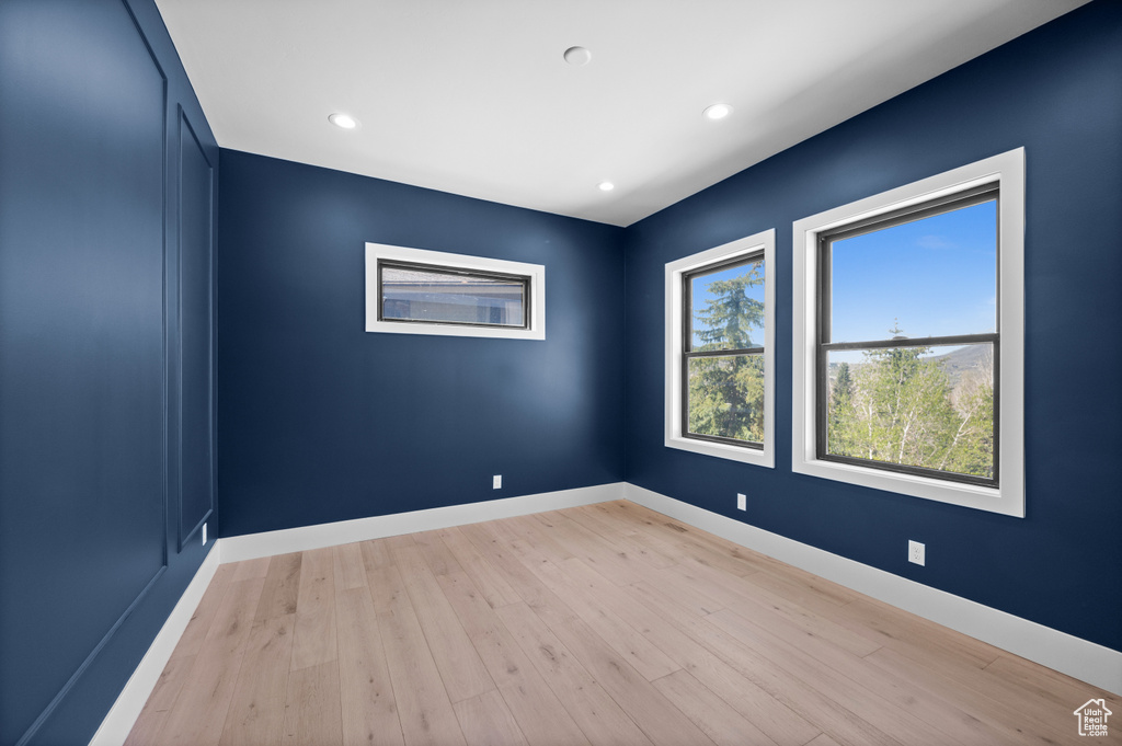 Unfurnished room featuring light wood-style flooring, baseboards, and recessed lighting