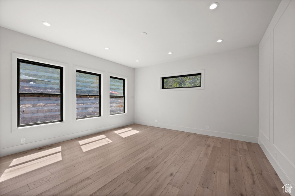 Spare room featuring light wood-style flooring, recessed lighting, and baseboards