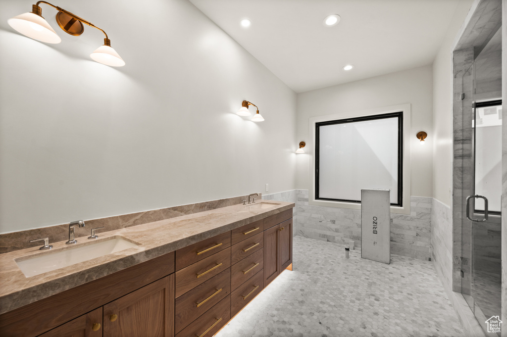 Bathroom with recessed lighting, a stall shower, tile walls, wainscoting, and double vanity