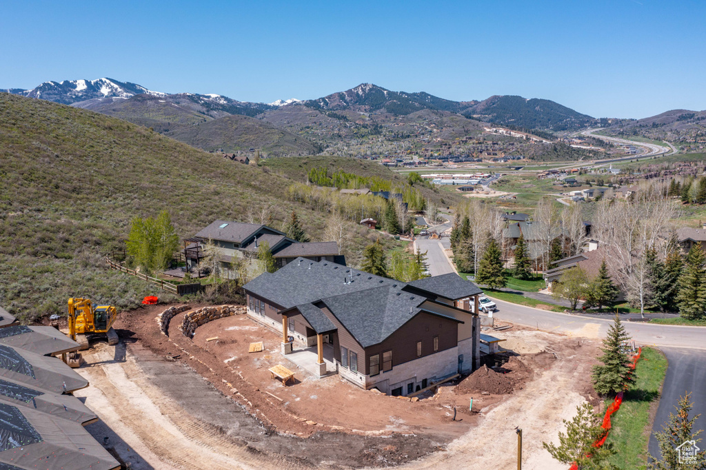 Aerial view of property and surrounding area with a mountain backdrop