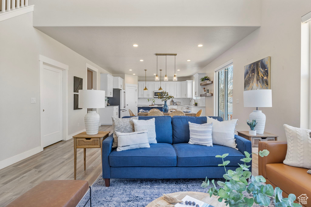 Living area featuring baseboards, recessed lighting, and light wood-style floors