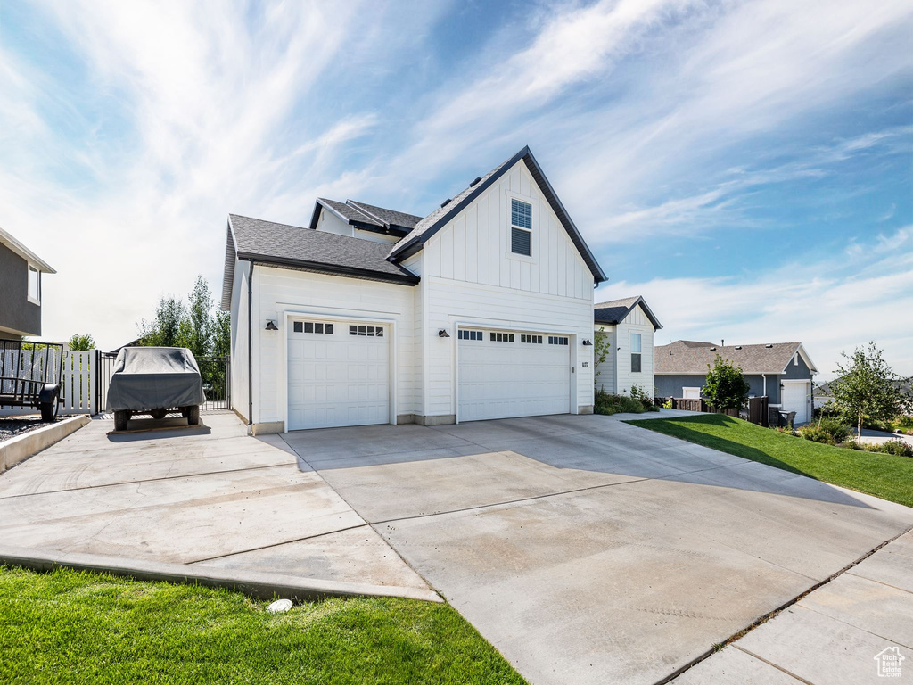 View of home\'s exterior with a garage and a lawn