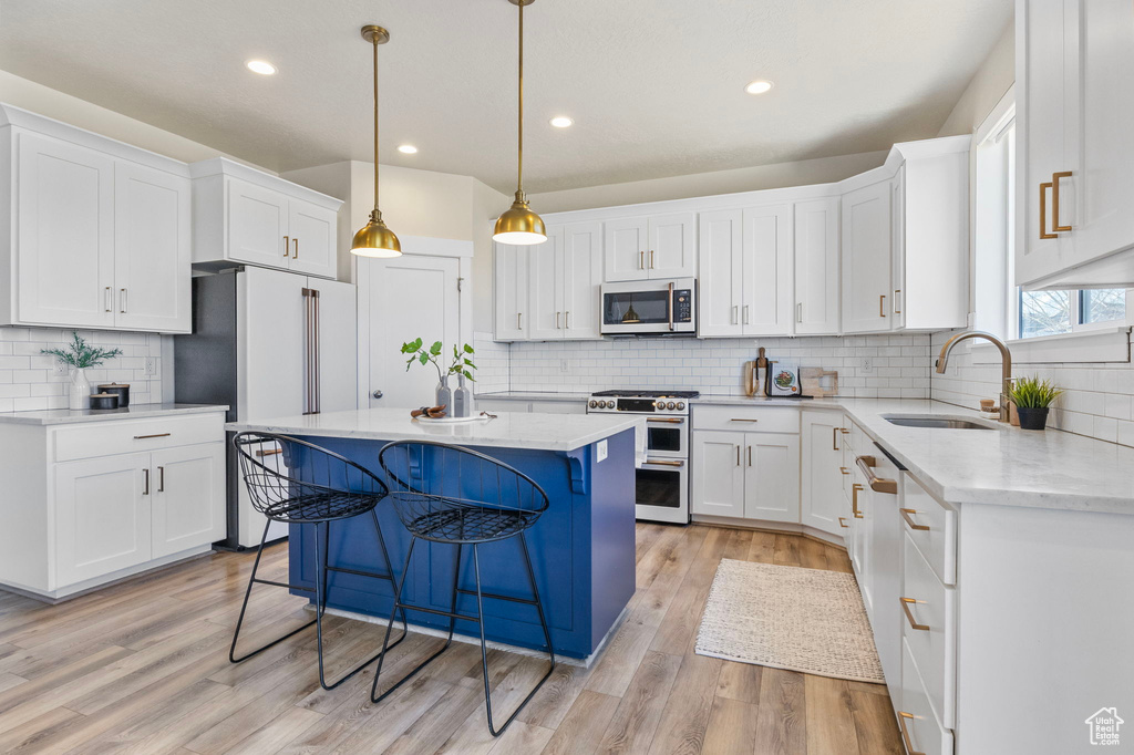 Kitchen with light wood-type flooring, double oven range, a sink, and a center island