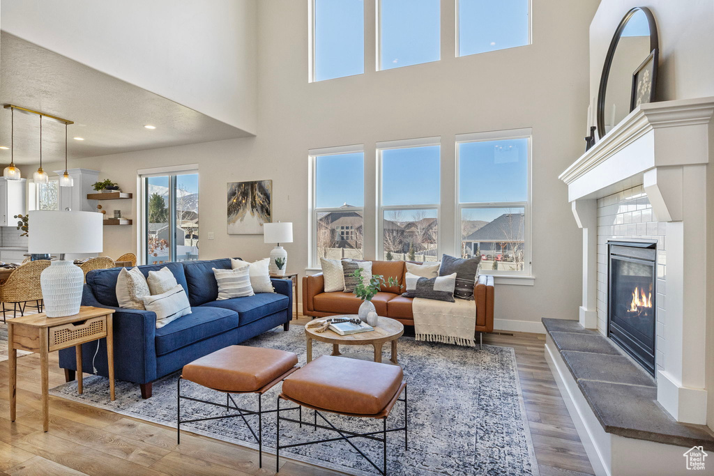 Living room with recessed lighting, a fireplace, wood finished floors, and baseboards