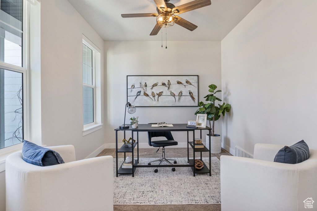 Carpeted office featuring ceiling fan, visible vents, and baseboards