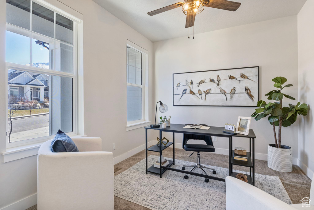 Office space with carpet floors, a ceiling fan, and baseboards