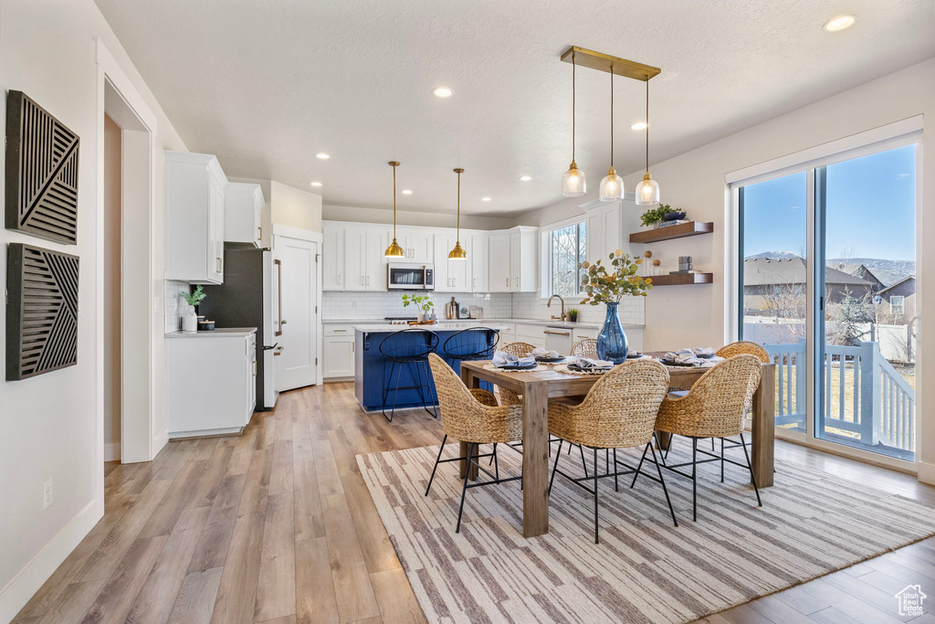 Dining space with light wood-style flooring, visible vents, baseboards, and recessed lighting