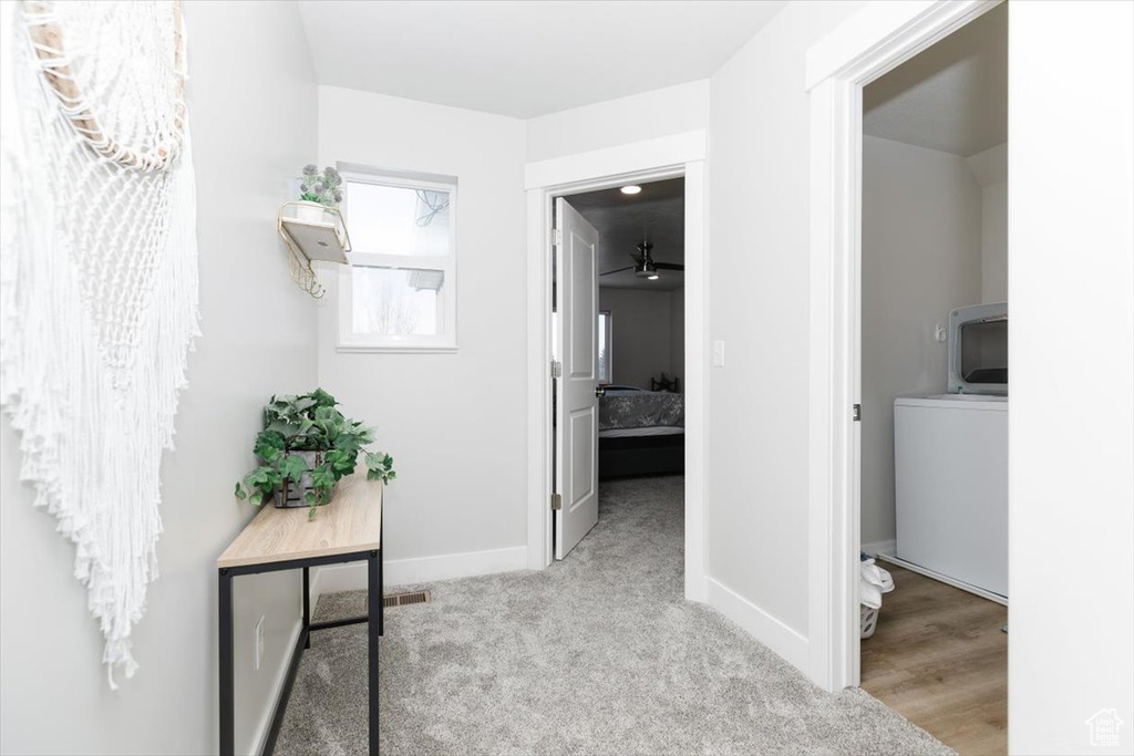 Hall with washer / dryer and light colored carpet