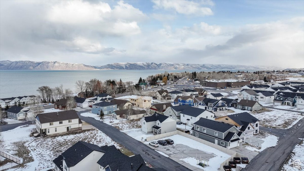 Snowy aerial view featuring a water and mountain view