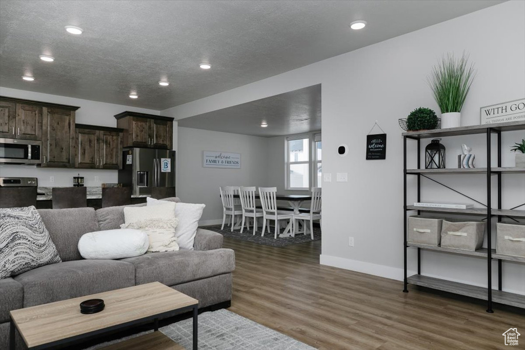 Living room with dark hardwood / wood-style flooring and a textured ceiling