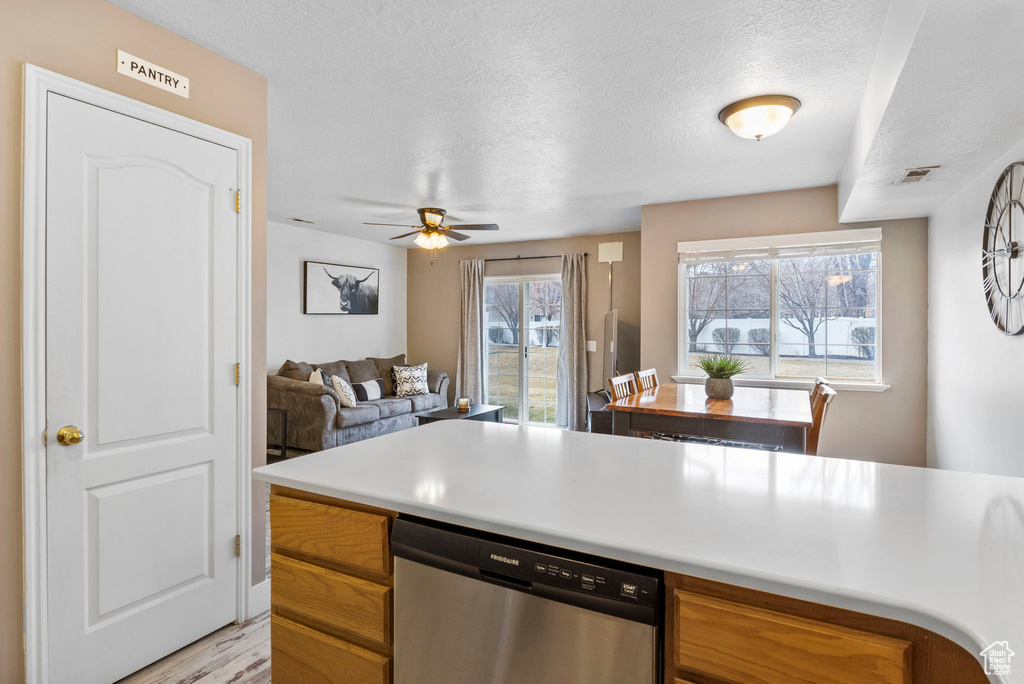 Kitchen featuring ceiling fan, a textured ceiling, light hardwood / wood-style floors, and dishwasher