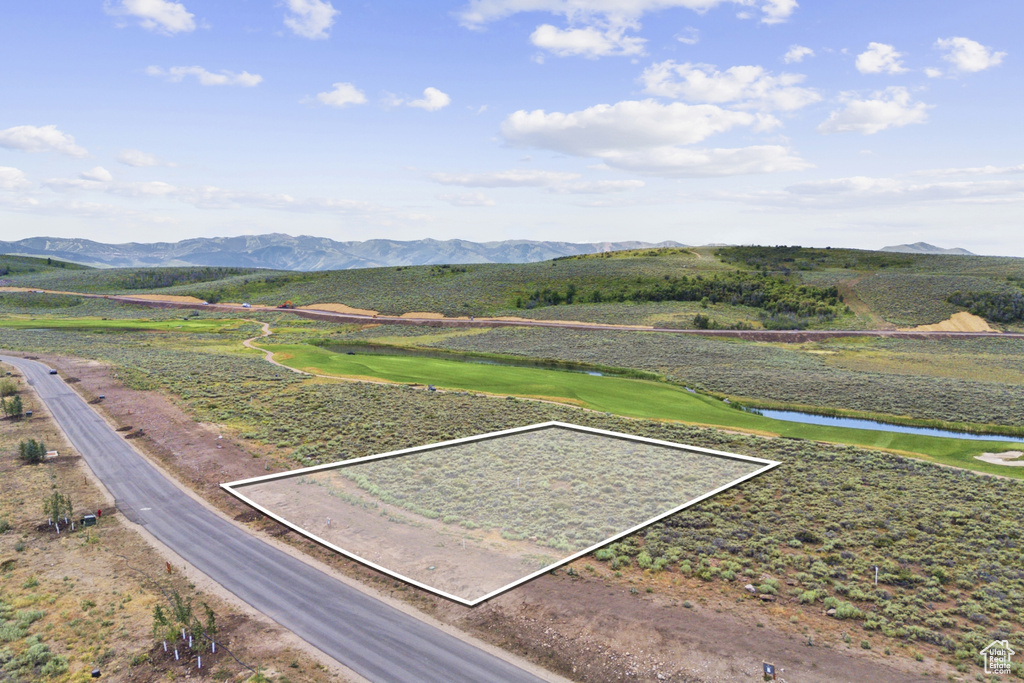 View of mountain background featuring a nearby body of water and a local golf course