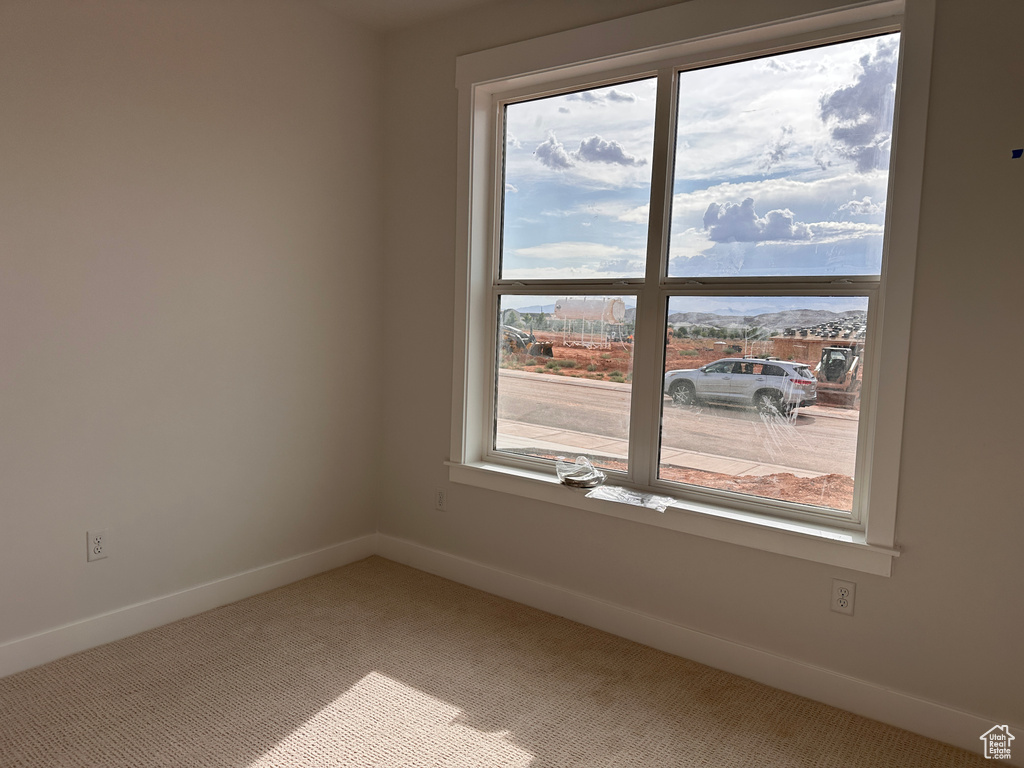 Empty room featuring carpet floors and plenty of natural light