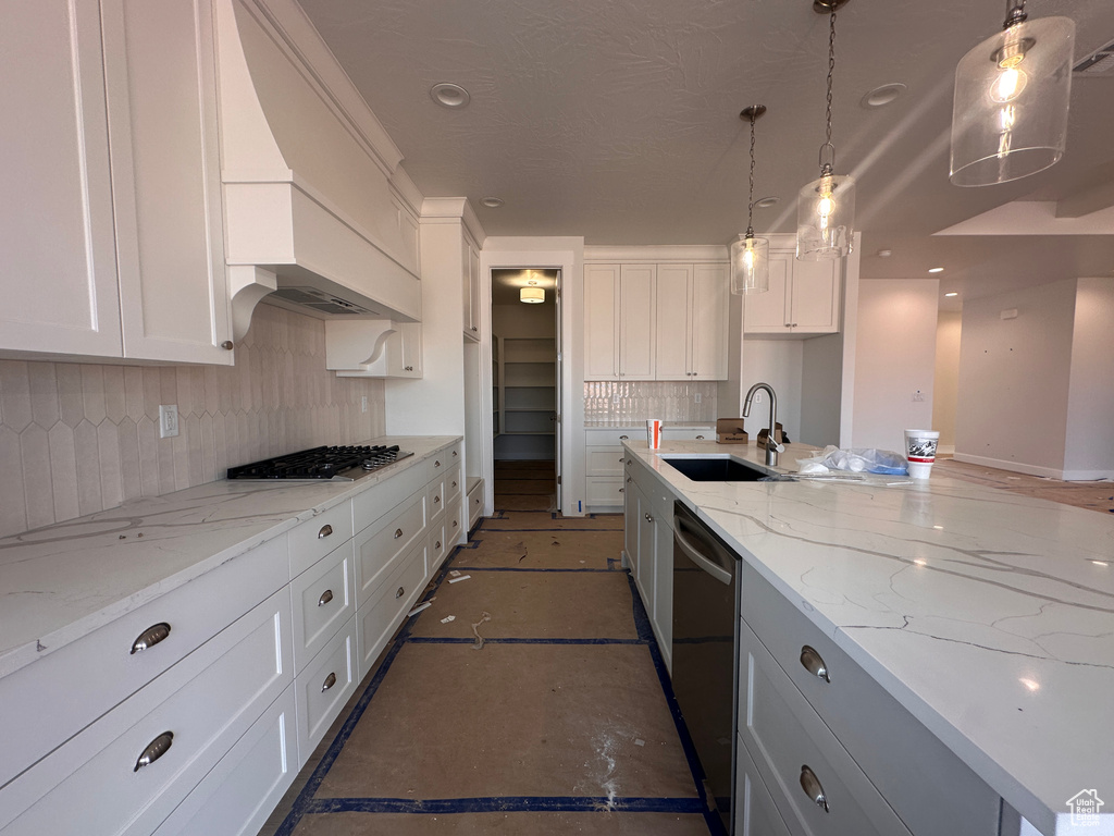 Kitchen featuring appliances with stainless steel finishes, decorative backsplash, white cabinets, and pendant lighting