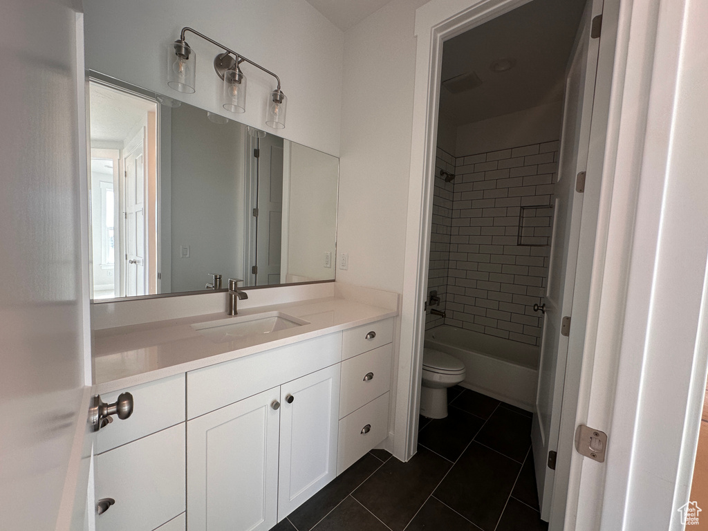 Bathroom featuring vanity, tile patterned floors, and  shower combination