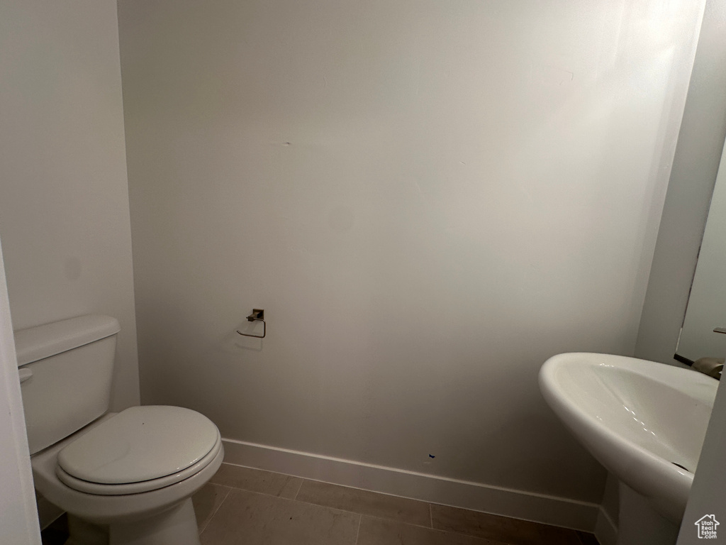 Half bathroom featuring baseboards and toilet