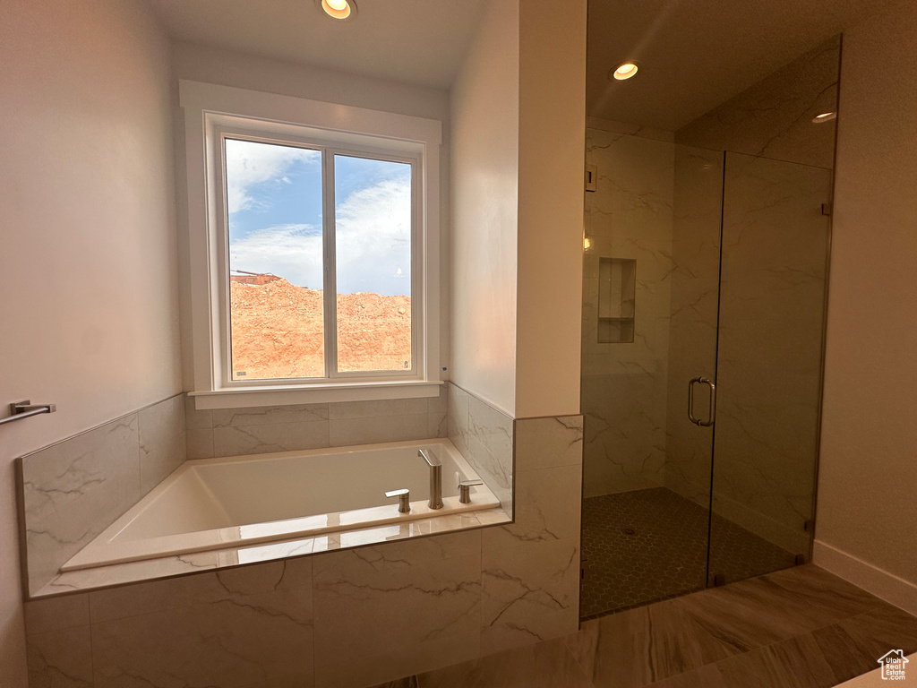 Bathroom with a marble finish shower, a garden tub, healthy amount of natural light, and recessed lighting