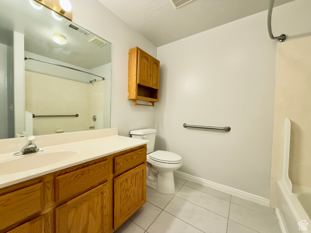 Bathroom featuring vanity, tile patterned floors, and shower / washtub combination