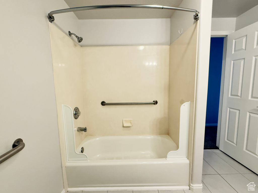 Bathroom with tile patterned flooring and shower / washtub combination