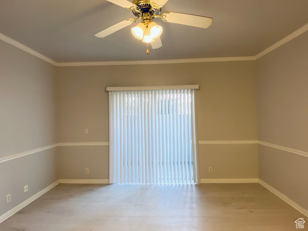 Unfurnished room featuring a ceiling fan, wood finished floors, and ornamental molding