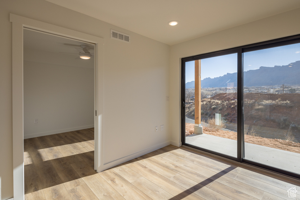 Spare room featuring a mountain view, wood finished floors, recessed lighting, and baseboards