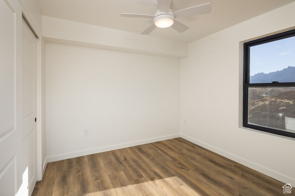 Unfurnished room with baseboards, wood finished floors, and a ceiling fan